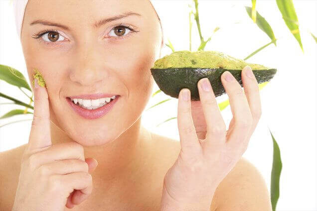 vrouw smeert masker met avocado op