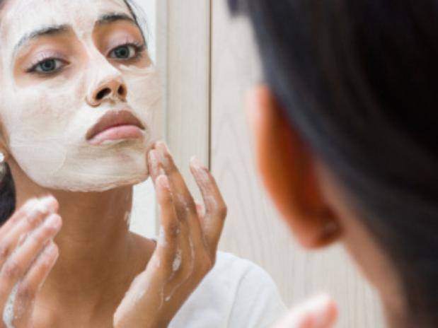 vrouw smeert creme op haar gezicht