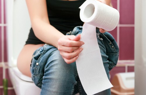 Vrouw met aambeien op het toilet