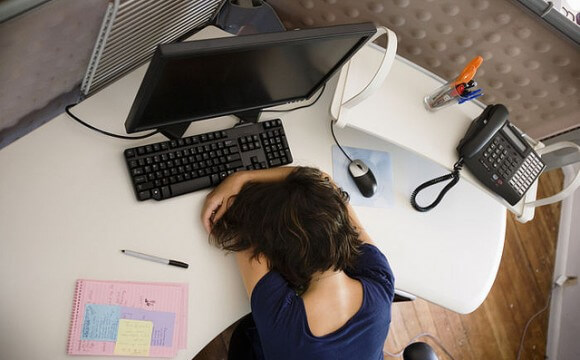 Vermoeide vrouw ligt op haar bureau