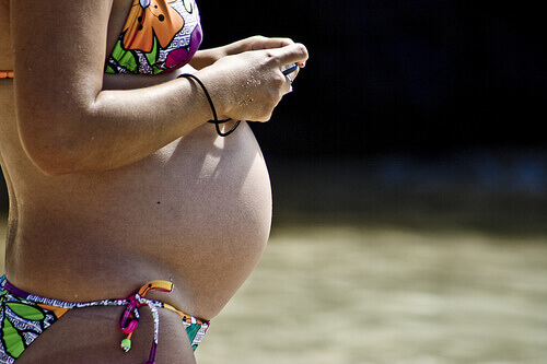Zwangere buik op het strand