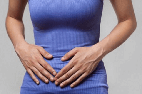 Vrouw met handen op de buik tegen maagkramp