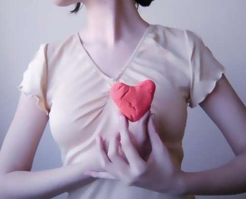 Vrouw houdt hart van klei voor borst