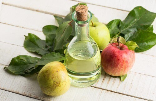 Appelazijn en appels op een tafel
