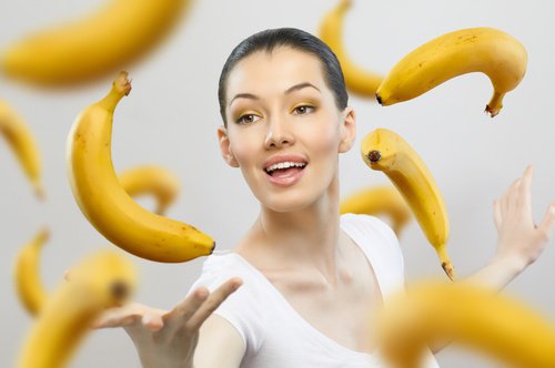 Vrouw met rijpe bananen om zich heen