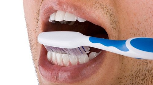 man poetst zijn tanden