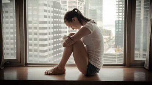 verdrietige vrouw bij een raam