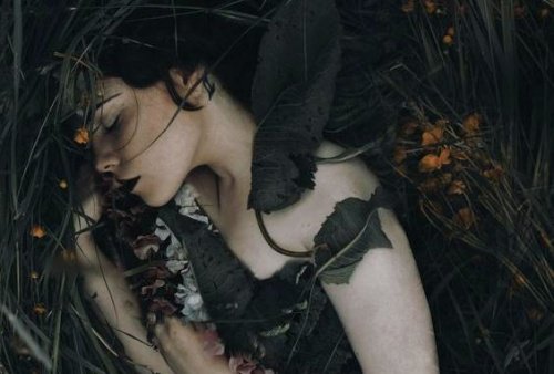 vrouw ligt tussen bladeren