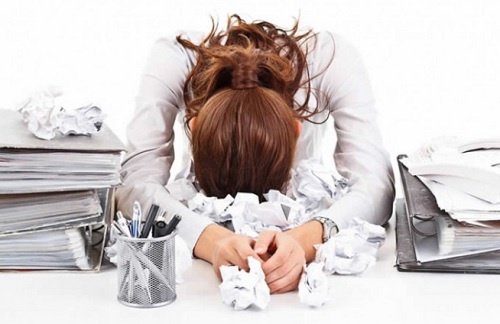 Overwerkte vrouw leunt op bureau