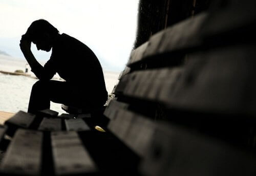 Een verdrietige man op een bankje