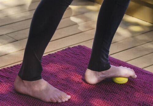 Met voet op tennisbal rollen