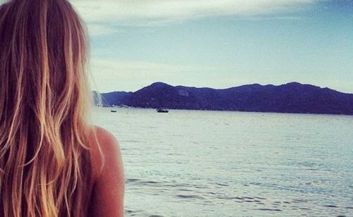 Vrouw die wegkijkt over zee