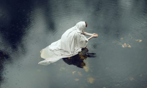 Vrouw in witte doek in het water