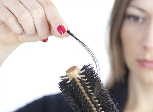 Vrouw Die Een Pluk Haar Uit Haar Borstel Haalt Omdat Ze Last Heeft Van Haaruitval Als Een Van De Symptomen Van Stress
