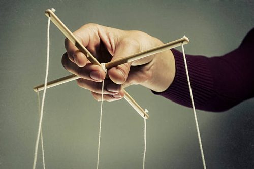 Hand Dat De Touwtjes Van Een Marionet Bestuurt