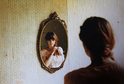 vrouw staat voor een spiegel