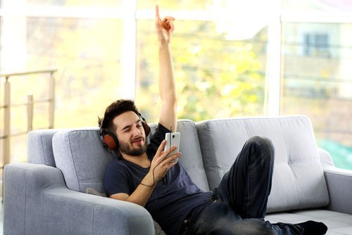 Man die muziek luistert op de bank