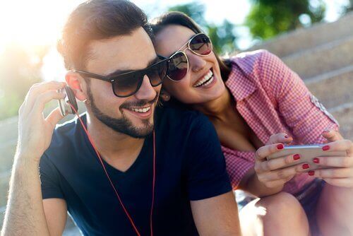 Lachende man en vrouw die muziek luisteren