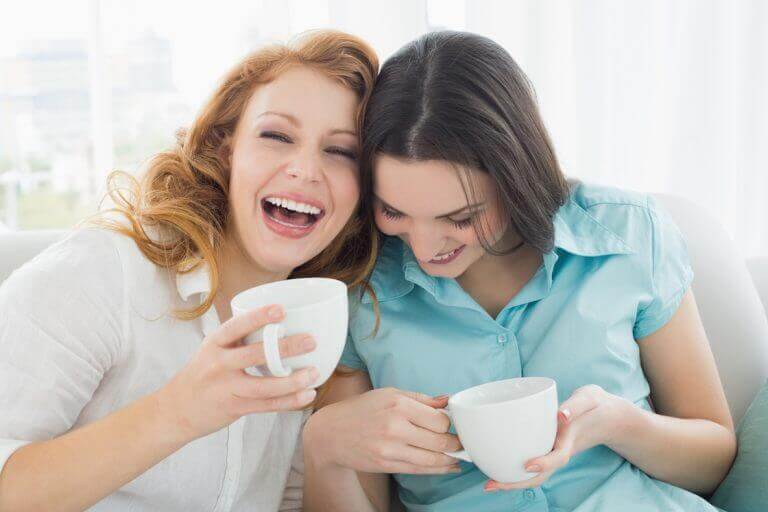 Twee vriendinnen die samen koffie drinken en lachen