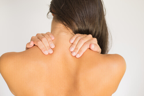 Vrouw die last heeft van een stijve nek en op zoek is naar oefeningen die nekpijn bestrijden