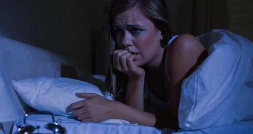 Vrouw die 's nachts wakker is omdat ze last heeft van nachtelijke paniekaanvallen