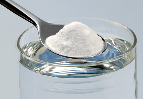 Lepel baking soda in een glas water