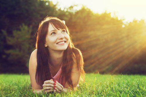 Vrouw vol optimisme in de zon in het gras