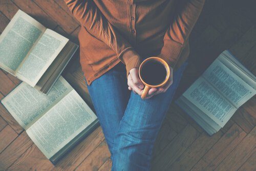 Vrouw met kop koffie en boeken