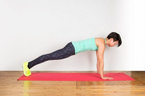 Vrouw doet de plank op yogamat