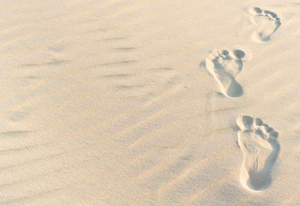 Niet bang zijn om alleen te zijn voetstappen in het zand