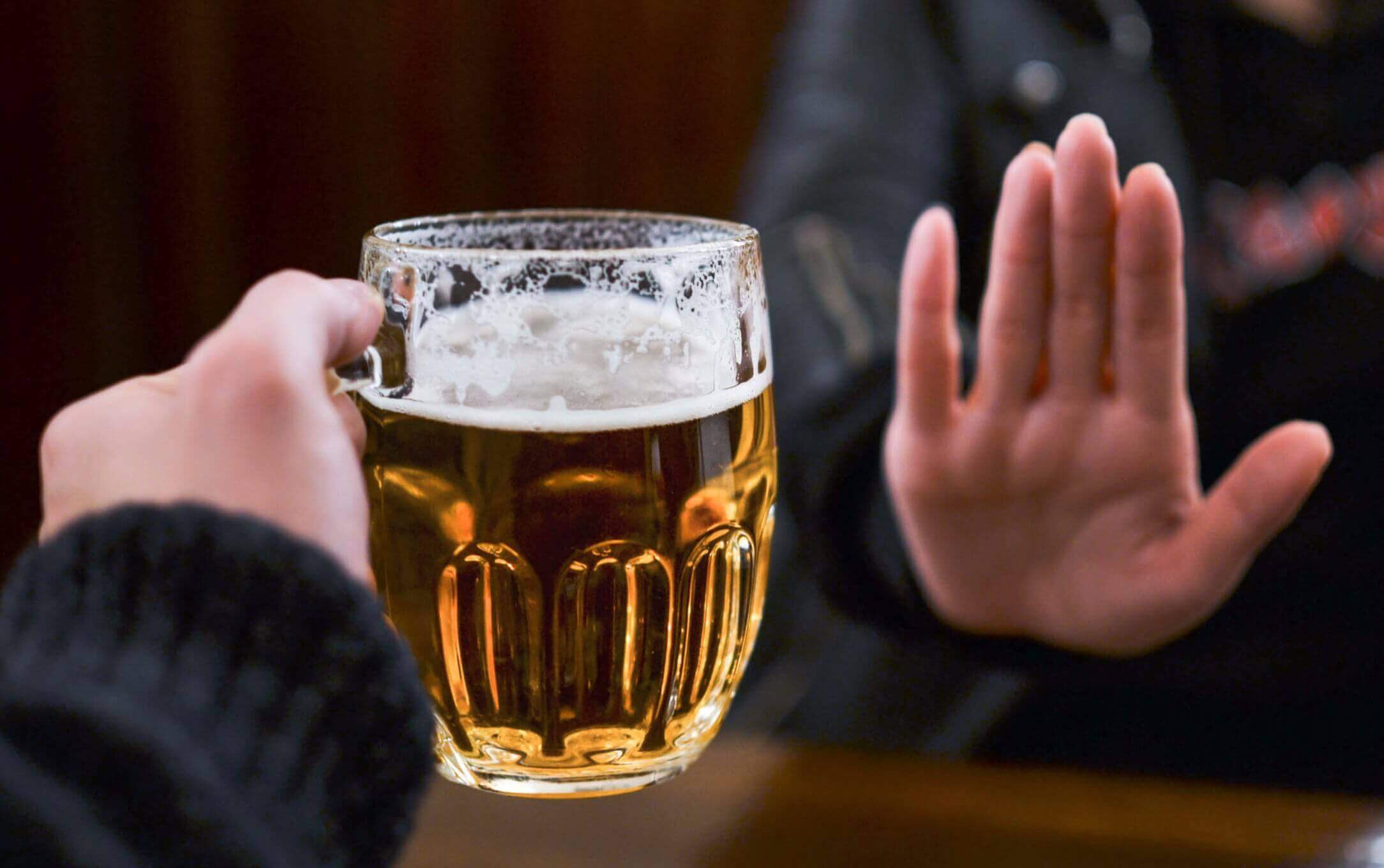 Vrouw die een glas bier krijgt aangeboden