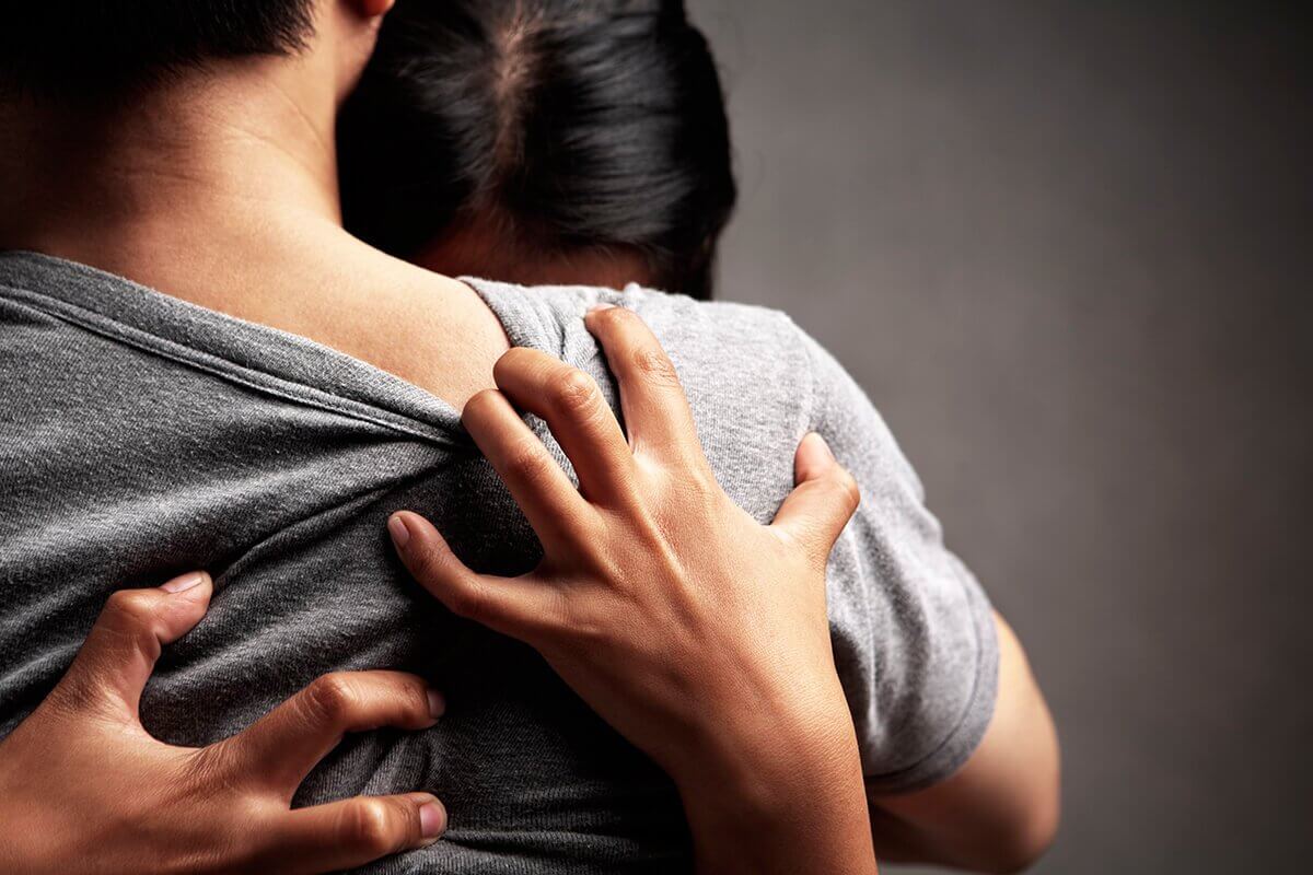 Vrouw klampt zich vast aan haar partner