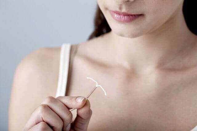 Vrouw die een spiraaltje vasthoudt, een van de mogelijke anticonceptiemethoden