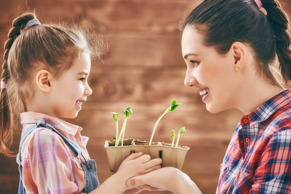 Supermoeder die plantjes plant met haar dochter