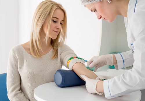 Verpleegster neemt bloed af bij vrouw