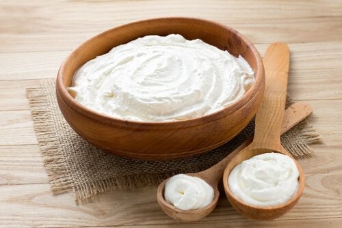 Houten kom en lepel met natuurlijke yoghurt