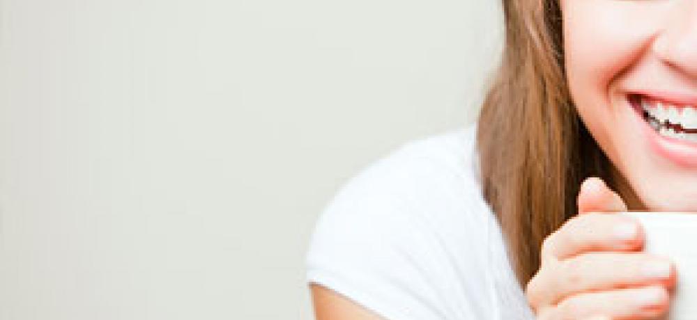 Lachende vrouw met kopje koffie