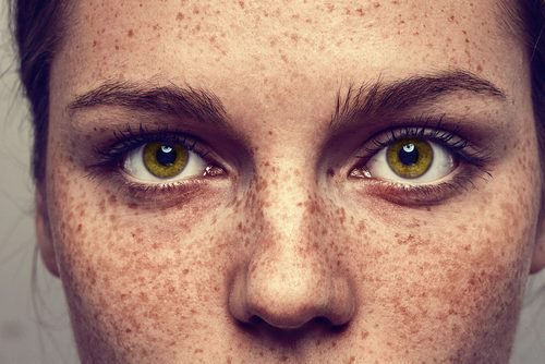 Vrouw met sproeten en groene ogen