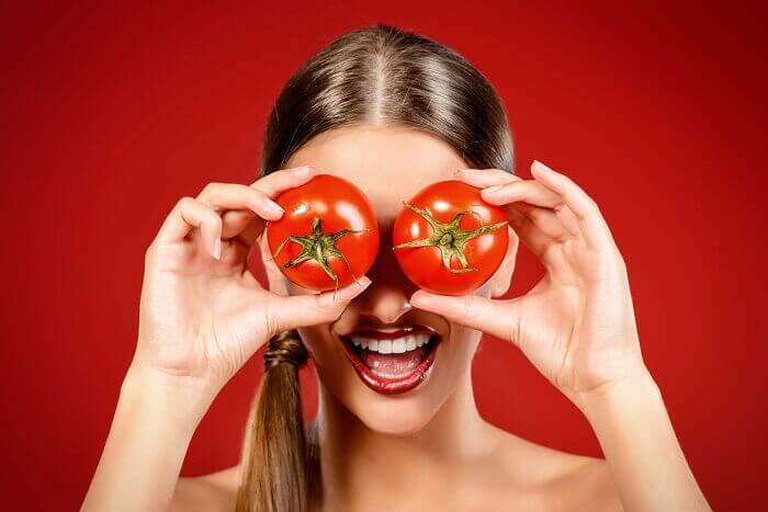 Vrouw met tomaten voor haar ogen