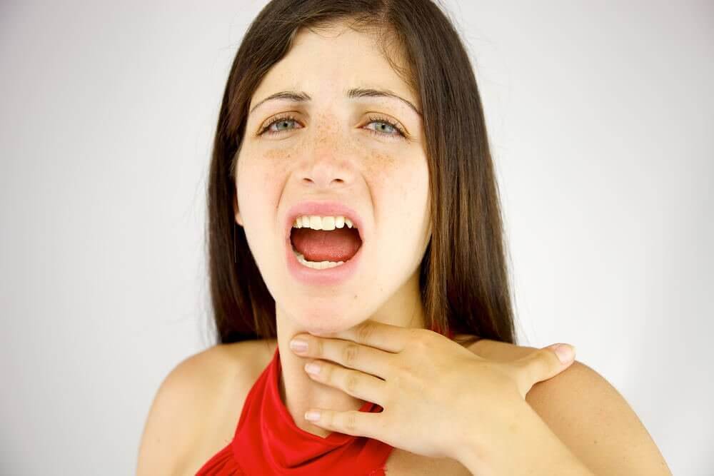 Vrouw raakt met hand pijnlijke keel aan