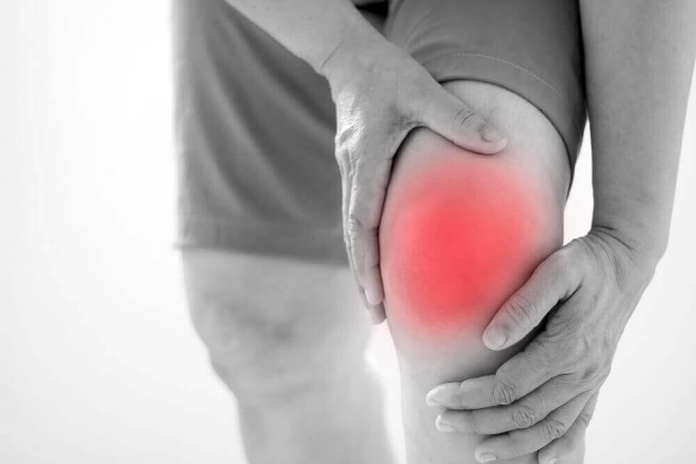Mannenhanden houden knie vast