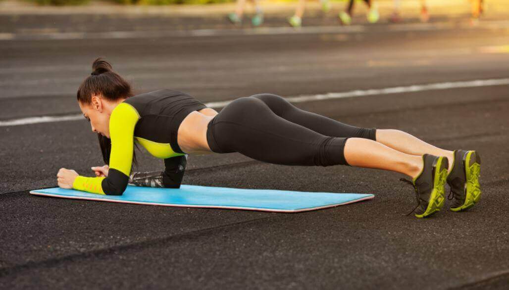 Vrouw die de plank doet om mooie buikspieren te krijgen