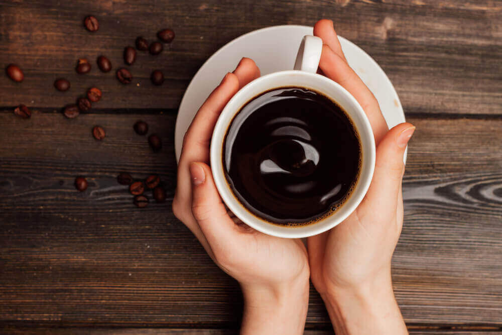 Handen houden kop koffie vast
