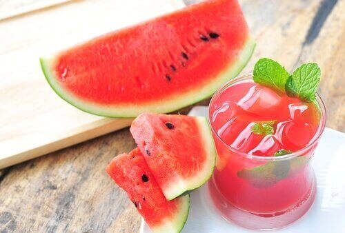 Plakken watermeloen en glas watermeloensap