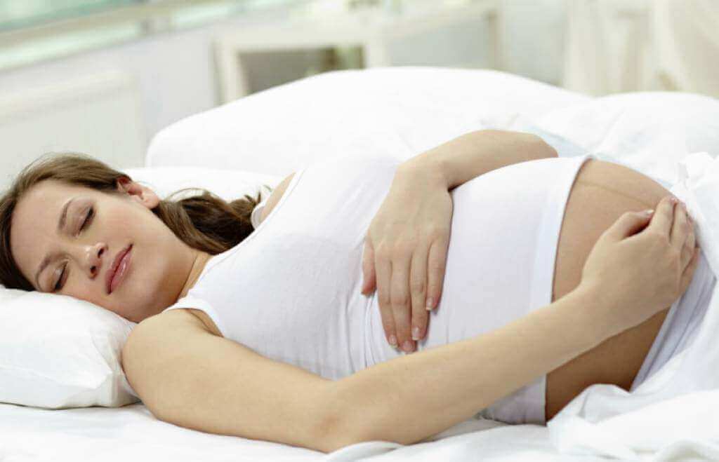 Zwangere vrouw slaapt op haar rug