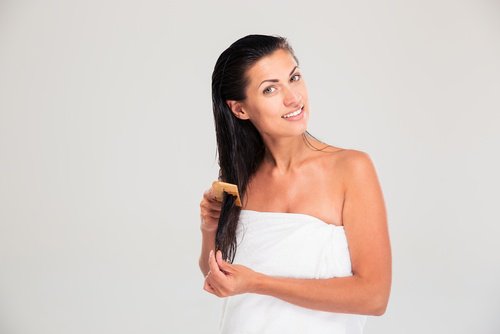 Vrouw die haar haar verzorgt om gespleten haarpuntjes te voorkomen