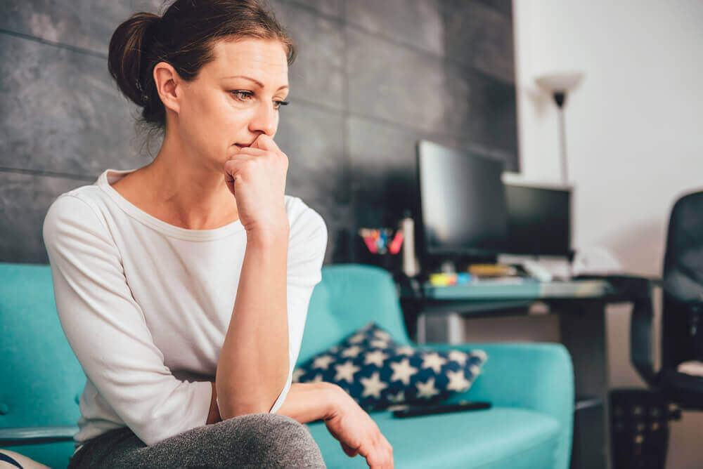 Vrouw zit verdrietig op de bank