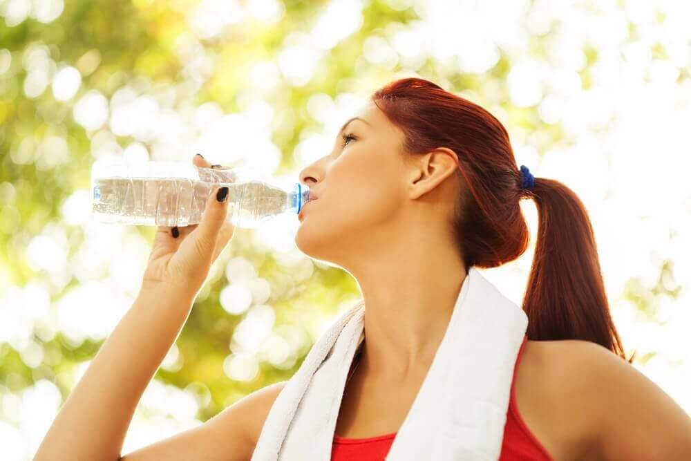 Vrouw die mineraalwater drinkt tijdens het trainen