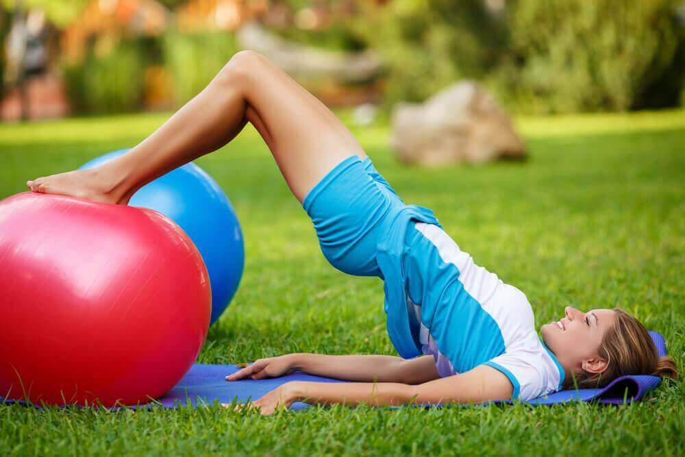 Vrouw doet de brug met een fitnessbal