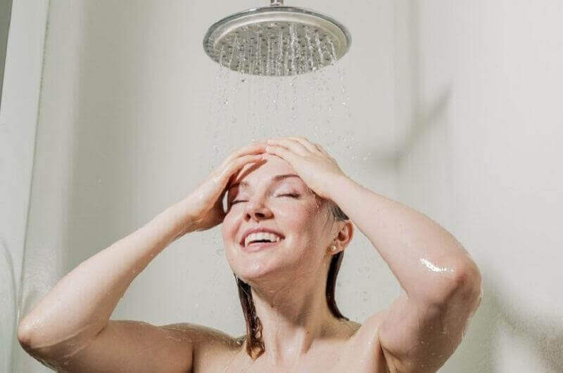 Vrouw geniet onder de douche